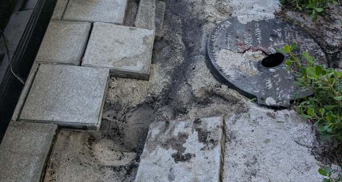 Washout and leak beside the driveway